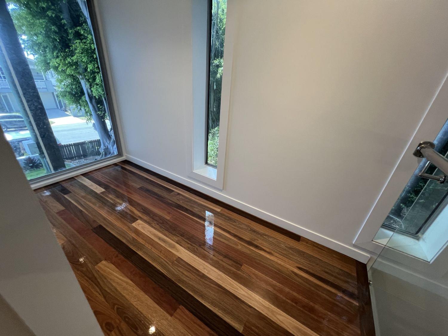 Bright room with glass sliding doors, a narrow window, shiny hardwood floors and white walls.