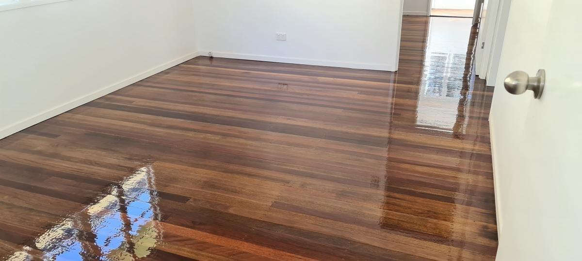 Empty room with polished hardwood floors and white walls.